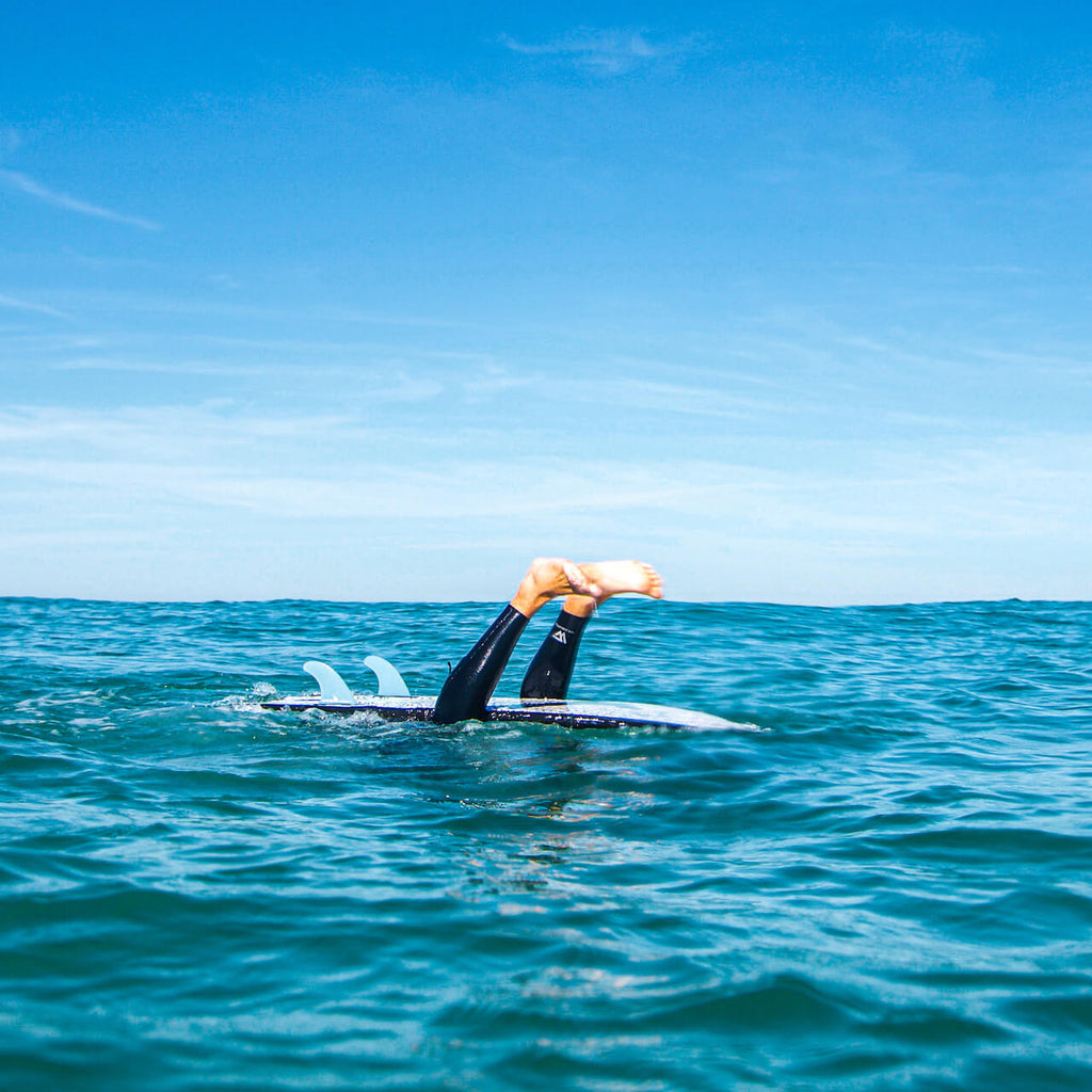 surfeur tete dans l'eau pied en l'air